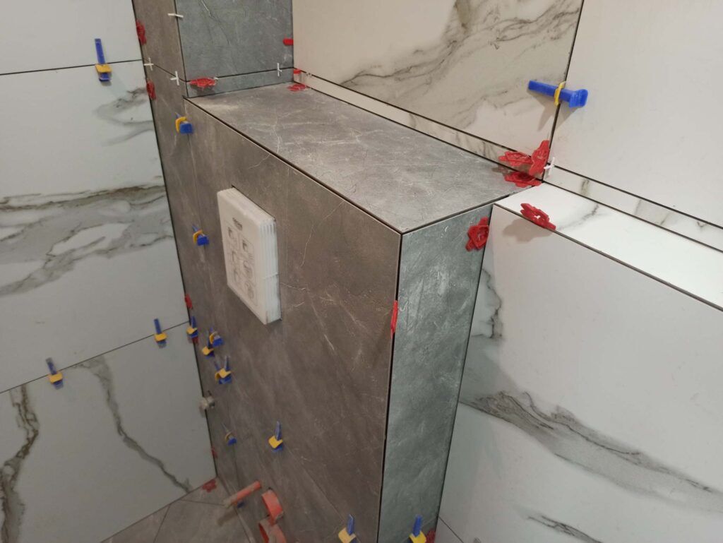 Ремонт на баня в Бургас Професионално полагане на плочки в баня с дистанционери - прецизен монтаж на широкоформатни плочки с мраморен ефект в Бургас