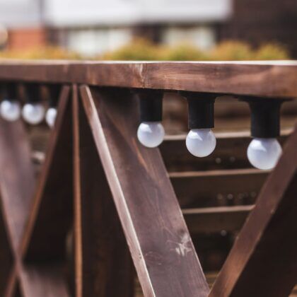 Стилно осветление от бели крушки монтирани по страниците на дървена беседка