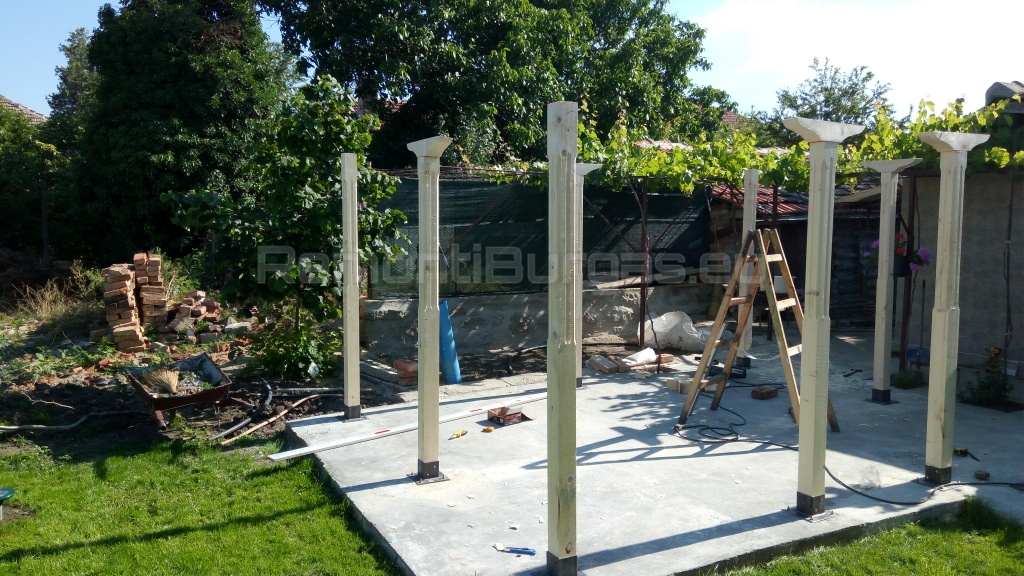 Дървен скелет на беседка в процес на изграждане с монтирани основни колони