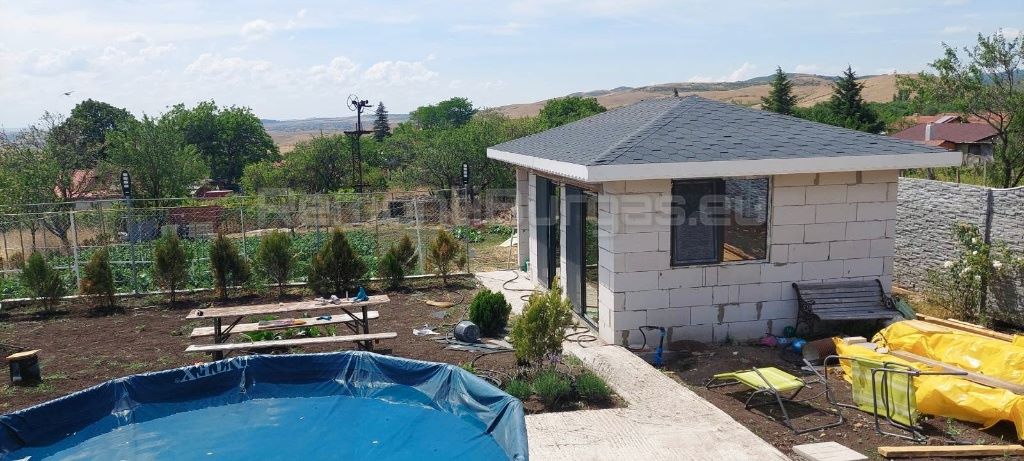 Частично завършена сграда с газобетонни блокове, нов покрив от битумни керемиди и нови врати с прозорци в Бургас